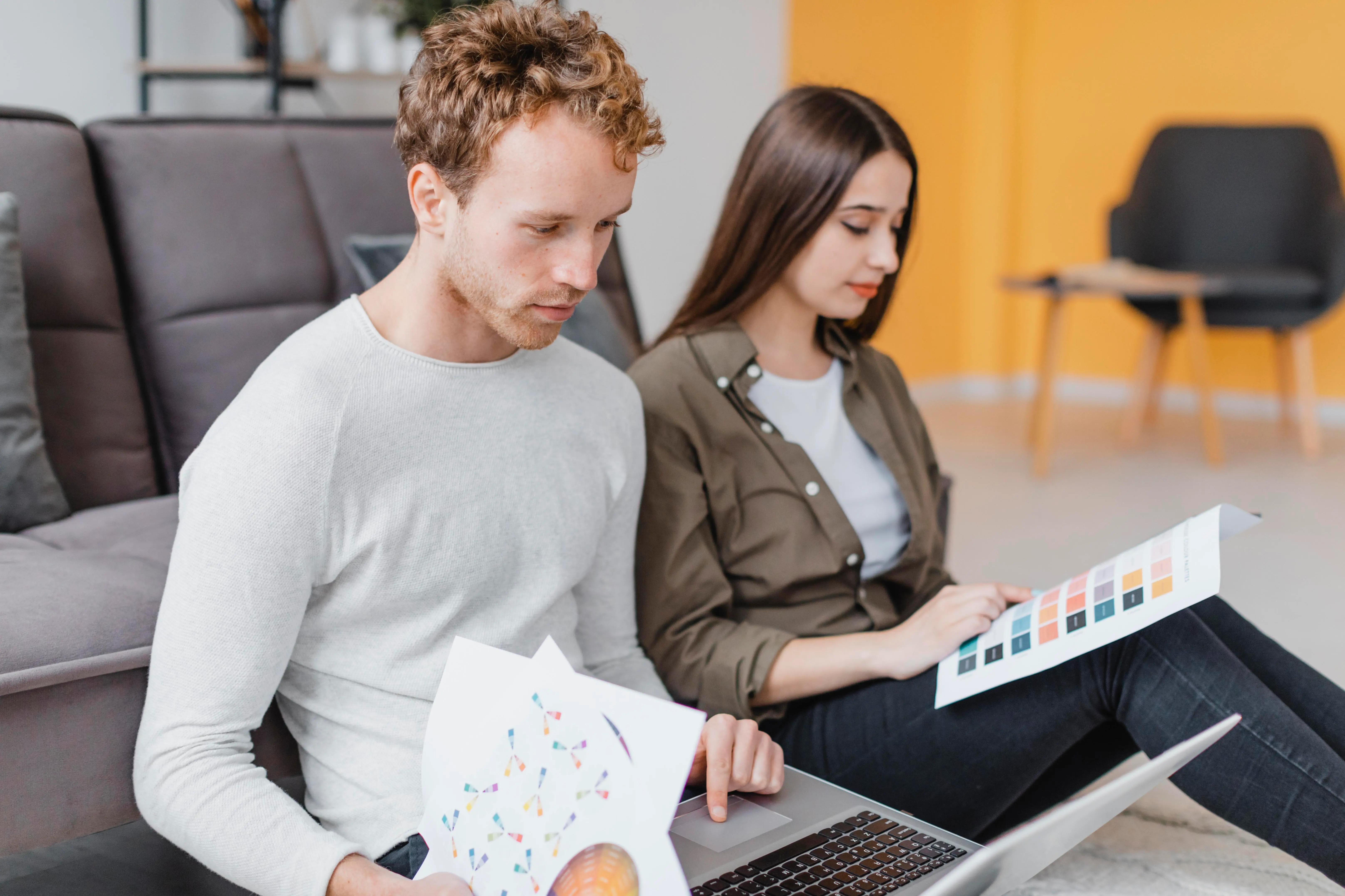 Two people at home comparing ecommerce platform options on a laptop while planning a big build decision in Shopify vs WooCommerce together