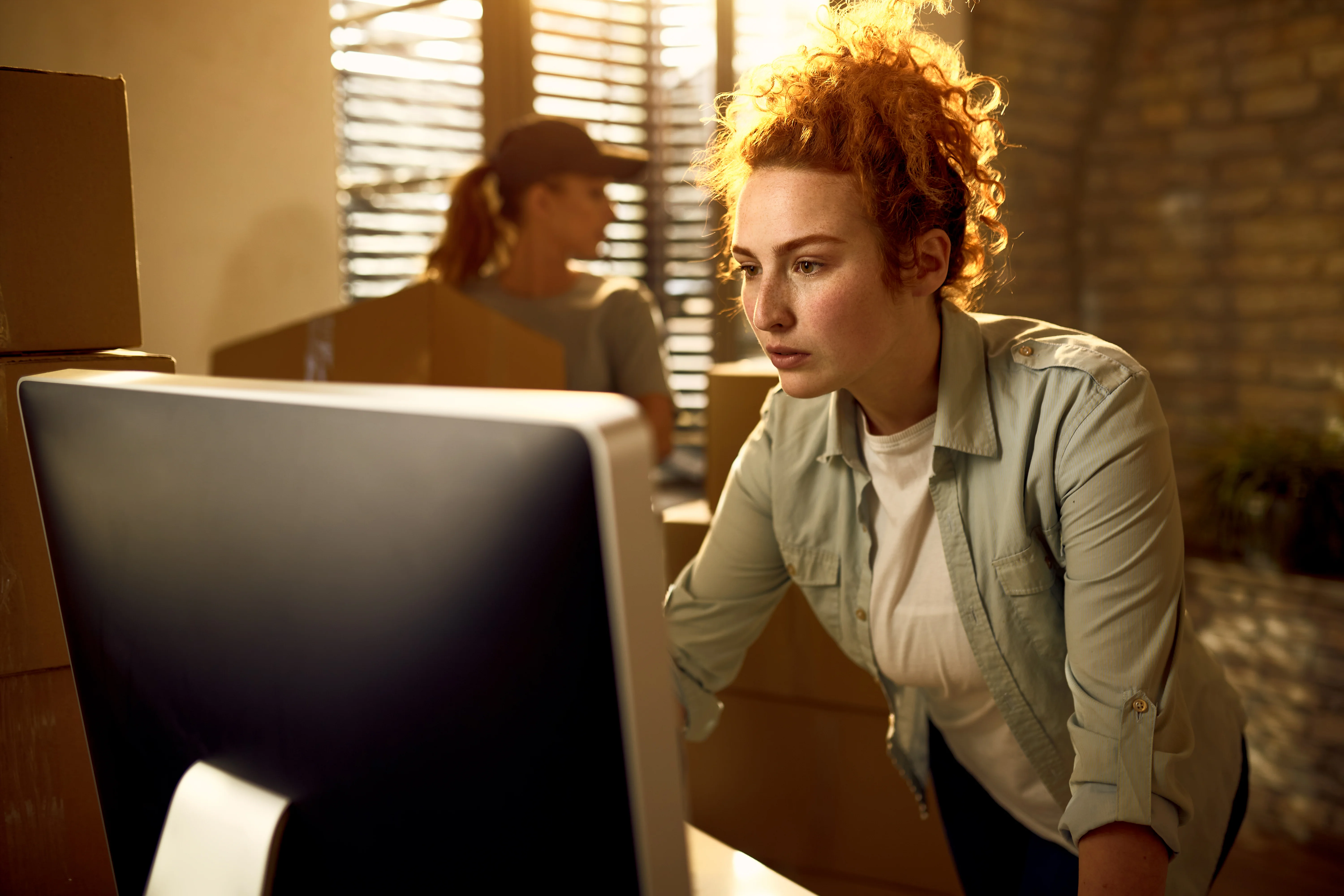 Ecommerce operations manager reviewing discontinued product data on a computer while deciding how to handle discontinued and out of stock pages